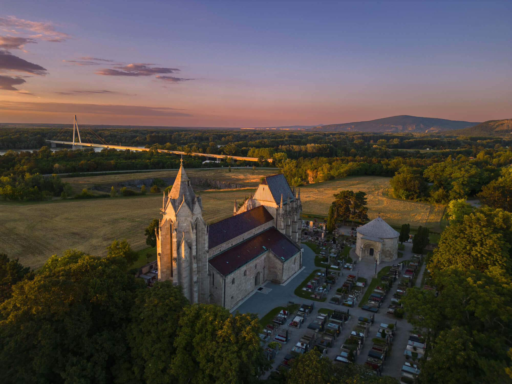 Luftaufnahme der Marienkirche in Bad Deutsch-Altenburg bei Sonnenuntergang.